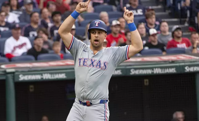 Texas Rangers' Nathaniel Lowe reacts after scoring on a two-run single by Leody Taveras during the second inning of a baseball game against the Cleveland Guardians in Cleveland, Friday, Aug. 23, 2024. (AP Photo/Phil Long)