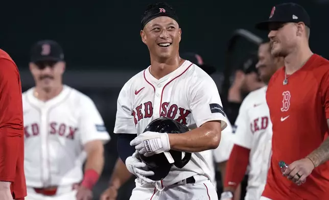 Boston Red Sox's Rob Refsnyder, center, celebrates after his winning RBI single in the 10th inning of a baseball game against the Texas Rangers at Fenway Park, Monday, Aug. 12, 2024, in Boston. (AP Photo/Charles Krupa)