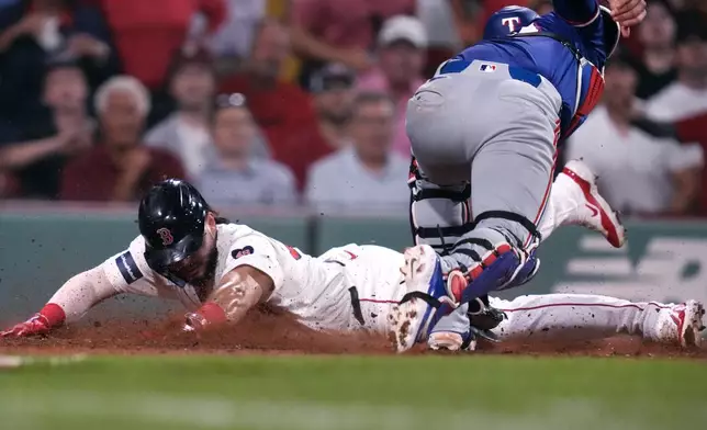 Boston Red Sox's Wilyer Abreu, left, beats the tag by Texas Rangers catcher Carson Kelly to score on a single by Dominic Smith during the eighth inning of a baseball game at Fenway Park, Tuesday, Aug. 13, 2024, in Boston. (AP Photo/Charles Krupa)