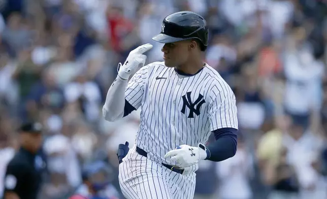 New York Yankees' Juan Soto gestures to his dugout after hitting a home run in the seventh inning, his second of the game, during a baseball game against the Texas Rangers, Sunday, Aug. 11, 2024, in New York. (AP Photo/John Munson)