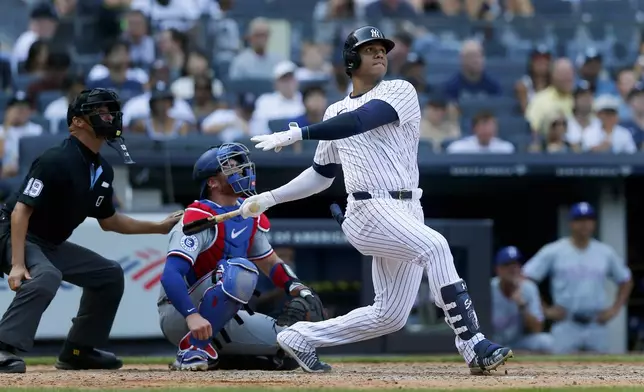 New York Yankees' Juan Soto hits a home run in the seventh inning, his second of the game, during a baseball game against the Texas Rangers, Sunday, Aug. 11, 2024, in New York. (AP Photo/John Munson)