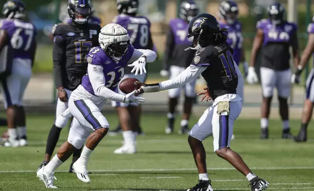 Baltimore Ravens quarterback Emory Jones (10) hands the ball off to running back John Kelly Jr. (33) during an NFL football joint training camp practice with the Green Bay Packers Thursday, Aug. 22, 2024, in Green Bay, Wis. (AP Photo/Matt Ludtke)