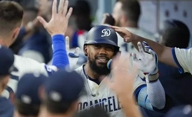 Los Angeles Dodgers' Teoscar Hernández (37) celebrates in the dugout after hitting a home run during the fourth inning of a baseball game against the Tampa Bay Rays in Los Angeles, Saturday, Aug. 24, 2024. Mookie Betts also scored. (AP Photo/Ashley Landis)