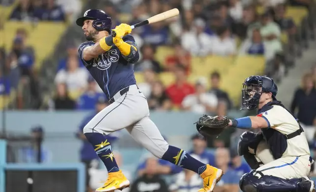 Tampa Bay Rays' José Caballero hits a home run during the tenth inning of a baseball game against the Los Angeles Dodgers in Los Angeles, Saturday, Aug. 24, 2024. Jonny DeLuca also scored. (AP Photo/Ashley Landis)