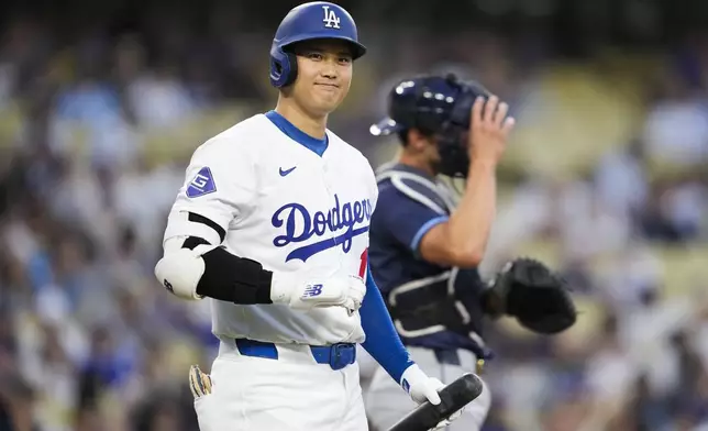 Los Angeles Dodgers designated hitter Shohei Ohtani (17) greets the Tampa Bay Rays dugout during the first inning of a baseball game in Los Angeles, Friday, Aug. 23, 2024. (AP Photo/Ashley Landis)