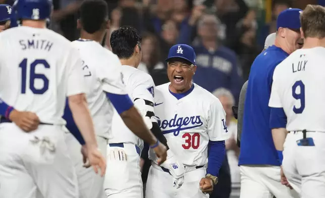 Los Angeles Dodgers designated hitter Shohei Ohtani (17) celebrates with manager Dave Roberts (30) after hitting a grand slam during the ninth inning of a baseball game against the Tampa Bay Rays in Los Angeles, Friday, Aug. 23, 2024. The Dodgers won 7-3. Will Smith, Tommy Edman, and Max Muncy also scored. (AP Photo/Ashley Landis)