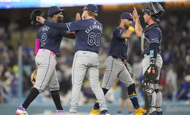 The Tampa Bay Rays celebrate after a 9-8 win over the Los Angeles Dodgers in a baseball game in Los Angeles, Saturday, Aug. 24, 2024. (AP Photo/Ashley Landis)