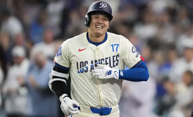 Los Angeles Dodgers designated hitter Shohei Ohtani (17) reacts after hitting a home run during the fifth inning of a baseball game against the Tampa Bay Rays in Los Angeles, Saturday, Aug. 24, 2024. Miguel Rojas also scored. (AP Photo/Ashley Landis)