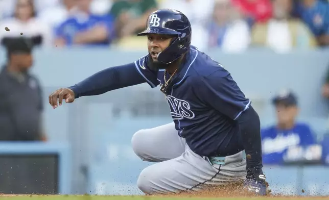 Tampa Bay Rays' Junior Caminero scores off of a double hit by Christopher Morel during the first inning of a baseball game against the Los Angeles Dodgers in Los Angeles, Saturday, Aug. 24, 2024. (AP Photo/Ashley Landis)