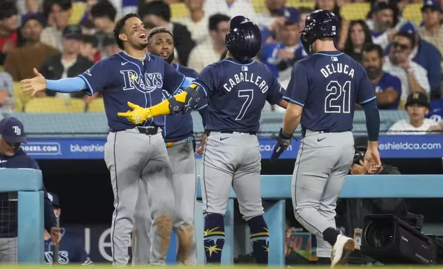 Tampa Bay Rays' José Caballero (7) celebrates after hitting a home run during the tenth inning of a baseball game against the Los Angeles Dodgers in Los Angeles, Saturday, Aug. 24, 2024. Jonny DeLuca (21) also scored. (AP Photo/Ashley Landis)