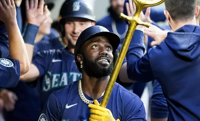 Seattle Mariners' Randy Arozarena looks up as he holds a trident to celebrate hitting a three-run home run against the Tampa Bay Rays during the third inning of a baseball game, Monday, Aug. 26, 2024, in Seattle. (AP Photo/Lindsey Wasson)