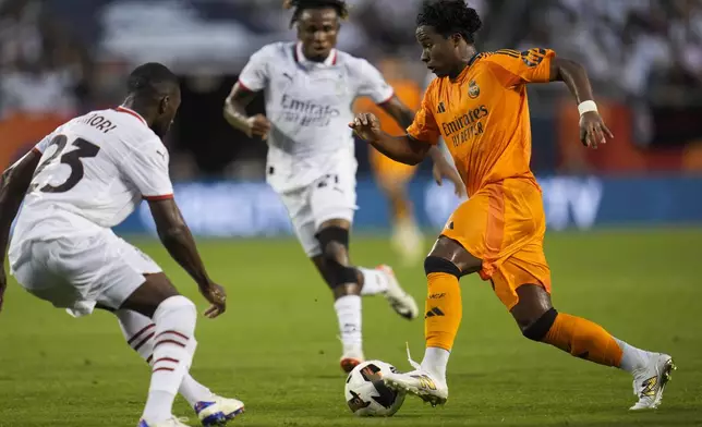 Real Madrid forward Endryck Moreira, right, dribbles the ball by Milan defender Fikayo Tomori during the first half of a friendly soccer match Wednesday, July 31, 2024, in Chicago. (AP Photo/Erin Hooley)