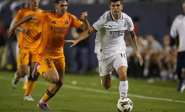 Real Madrid midfielder Mario Martín, left, and Milan forward Christian Pulisic chase the ball during the second half of a friendly soccer match Wednesday, July 31, 2024, in Chicago. (AP Photo/Erin Hooley)