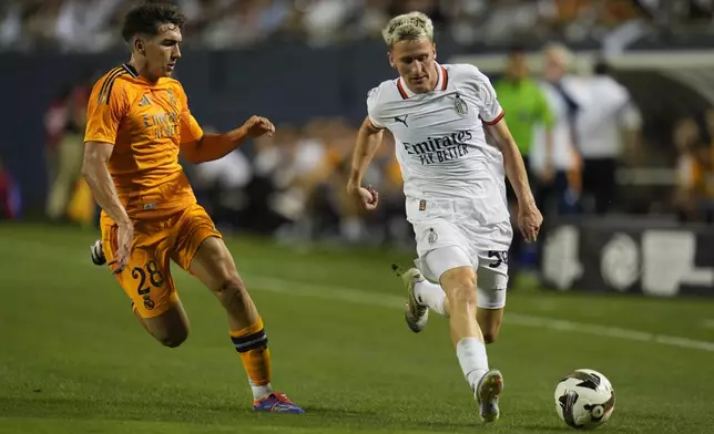 Real Madrid midfielder Mario Martín, left, and AC Milan midfielder Alexis Saelemaekers chase the ball during the second half of a friendly soccer match Wednesday, July 31, 2024, in Chicago.. (AP Photo/Erin Hooley)