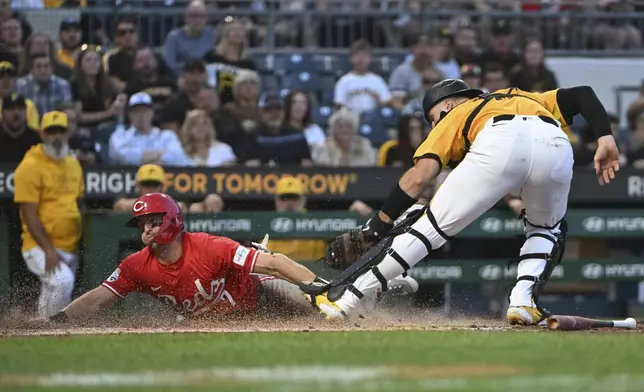 Cincinnati Reds' Spencer Steer (7) scores ahead of a tag by Pittsburgh Pirates catcher Joey Bart, right, on a sacrifice bunt in the fourth inning of a baseball game, Friday, Aug. 23, 2024, in Pittsburgh. (AP Photo/Barry Reeger)