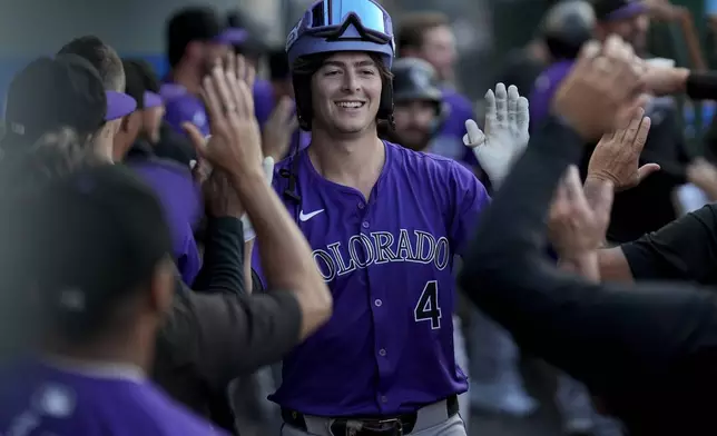 Colorado Rockies' Michael Toglia (4) celebrates in the dugout after hitting a home run during the second inning of a baseball game against the Los Angeles Angels in Anaheim, Calif., Thursday, Aug. 1, 2024. (AP Photo/Eric Thayer)