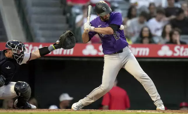 Colorado Rockies' Jacob Stallings, right, is hit by a pitch during the fifth inning of a baseball game against the Los Angeles Angels in Anaheim, Calif., Thursday, Aug. 1, 2024. (AP Photo/Eric Thayer)