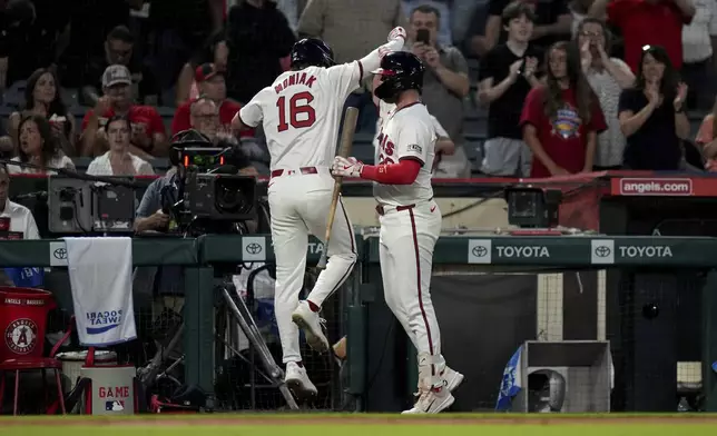 Los Angeles Angels' Mickey Moniak (16) celebrates with teammate Brandon Drury after hitting a home run during the sixth inning of a baseball game against the Colorado Rockies in Anaheim, Calif., Thursday, Aug. 1, 2024. (AP Photo/Eric Thayer)