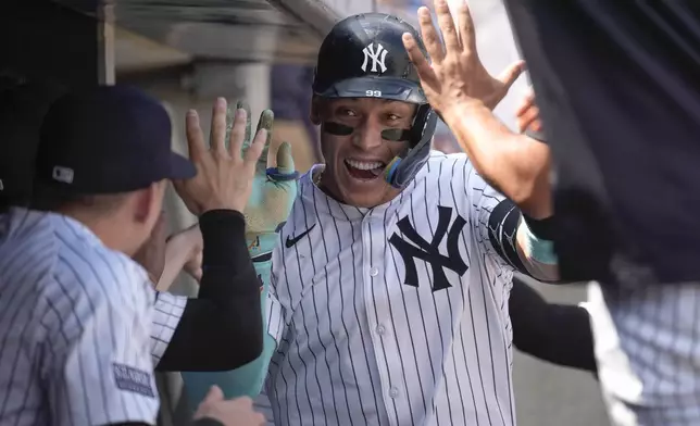 New York Yankees' Aaron Judge, center, celebrates with teammates after hitting a home run during the first inning of a baseball game against the Colorado Rockies, Sunday, Aug. 25, 2024, in New York. (AP Photo/Bryan Woolston)