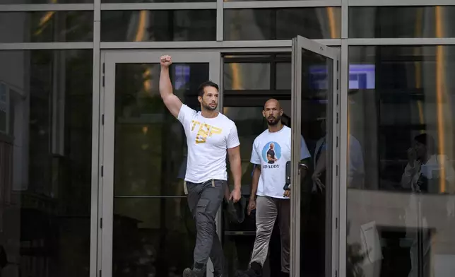 Andrew Tate, right, and his brother Tristan, left, exit the Bucharest Tribunal after being placed under house arrest, in Bucharest, Romania, Thursday, Aug. 22, 2024. A court in Romania's capital on Thursday placed the divisive internet influencer Andrew Tate under house arrest for 30 days, as prosecutors investigate a sprawling new case that involves allegations of human trafficking of minors and sex with a minor. (AP Photo/Alexandru Dobre)