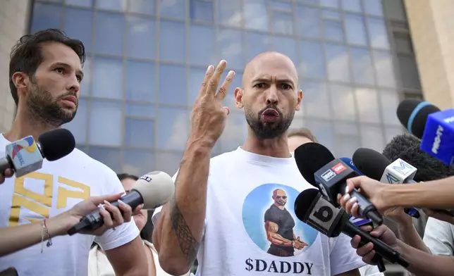 Andrew Tate speaks to media outside the Bucharest Tribunal after being placed under house arrest, in Bucharest, Romania, Thursday, Aug. 22, 2024. A court in Romania's capital on Thursday placed the divisive internet influencer Andrew Tate under house arrest for 30 days, as prosecutors investigate a sprawling new case that involves allegations of human trafficking of minors and sex with a minor. (AP Photo/Alexandru Dobre)