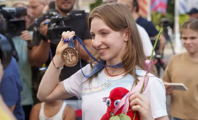 Romanian gymnast Ana Barbosu poses with the bronze medal for her women's artistic gymnastics individual floor performance at the Paris 2024 Olympics, after receiving it during a ceremony at the Romanian Olympic and Sports Committee, in Bucharest, Romania, Friday, Aug. 16, 2024. American gymnast Jordan Chiles called an arbitration panel's decision that dropped her out of the bronze medal position in the floor exercise at the Paris Olympics "unjust" and a "significant blow" in a message posted on social media Thursday. (AP Photo/Vadim Ghirda)