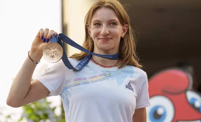 Romanian gymnast Ana Barbosu poses with the bronze medal for her women's artistic gymnastics individual floor performance at the Paris 2024 Olympics, after receiving it during a ceremony at the Romanian Olympic and Sports Committee, in Bucharest, Romania, Friday, Aug. 16, 2024. American gymnast Jordan Chiles called an arbitration panel's decision that dropped her out of the bronze medal position in the floor exercise at the Paris Olympics "unjust" and a "significant blow" in a message posted on social media Thursday. (AP Photo/Vadim Ghirda)