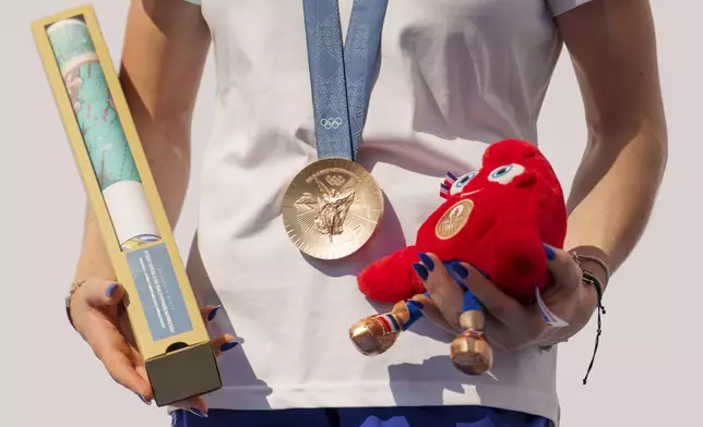 Romanian gymnast Ana Barbosu poses with the bronze medal for her women's artistic gymnastics individual floor performance at the Paris 2024 Olympics, after receiving it during a ceremony at the Romanian Olympic and Sports Committee, in Bucharest, Romania, Friday, Aug. 16, 2024. American gymnast Jordan Chiles called an arbitration panel's decision that dropped her out of the bronze medal position in the floor exercise at the Paris Olympics "unjust" and a "significant blow" in a message posted on social media Thursday. (AP Photo/Vadim Ghirda)