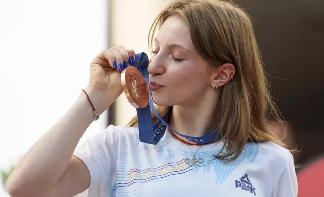 Romanian gymnast Ana Barbosu poses with the bronze medal for her women's artistic gymnastics individual floor performance at the Paris 2024 Olympics, after receiving it during a ceremony at the Romanian Olympic and Sports Committee, in Bucharest, Romania, Friday, Aug. 16, 2024. American gymnast Jordan Chiles called an arbitration panel's decision that dropped her out of the bronze medal position in the floor exercise at the Paris Olympics "unjust" and a "significant blow" in a message posted on social media Thursday. (AP Photo/Vadim Ghirda)