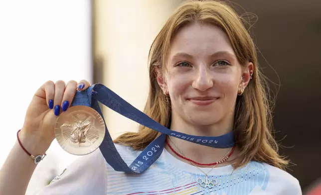 Romanian gymnast Ana Barbosu poses with the bronze medal for her women's artistic gymnastics individual floor performance at the Paris 2024 Olympics, after receiving it during a ceremony at the Romanian Olympic and Sports Committee, in Bucharest, Romania, Friday, Aug. 16, 2024. American gymnast Jordan Chiles called an arbitration panel's decision that dropped her out of the bronze medal position in the floor exercise at the Paris Olympics "unjust" and a "significant blow" in a message posted on social media Thursday. (AP Photo/Vadim Ghirda)