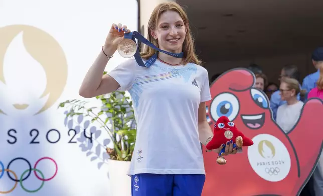 Romanian gymnast Ana Barbosu poses with the bronze medal for her women's artistic gymnastics individual floor performance at the Paris 2024 Olympics, after receiving it during a ceremony at the Romanian Olympic and Sports Committee, in Bucharest, Romania, Friday, Aug. 16, 2024. American gymnast Jordan Chiles called an arbitration panel's decision that dropped her out of the bronze medal position in the floor exercise at the Paris Olympics "unjust" and a "significant blow" in a message posted on social media Thursday. (AP Photo/Vadim Ghirda)