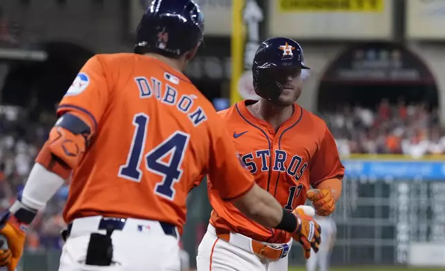 Houston Astros' Ben Gamel, right, is congratulated by Mauricio Dubón (14) after hitting a solo home run during the third inning of a baseball game against the Kansas City Royals, Friday, Aug. 30, 2024, in Houston. (AP Photo/Kevin M. Cox)