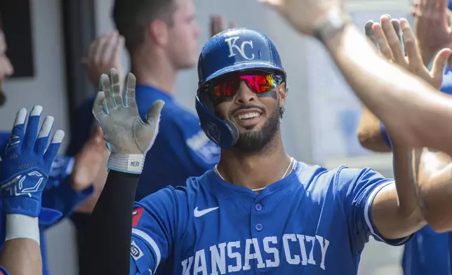 Kansas City Royals' MJ Melendez is congratulated by his teammates after hitting a three-run home run off Cleveland Guardians relief pitcher Eli Morgan during the fourth inning of the first game of a baseball doubleheader in Cleveland, Monday, Aug. 26, 2024. (AP Photo/Phil Long)