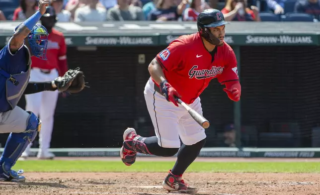 Cleveland Guardians' Josh Naylor, right, watches his RBI single off Kansas City Royals relief pitcher Kris Bubic with Salvador Perez, left, during the seventh inning of the first game of a baseball doubleheader in Cleveland, Monday, Aug. 26, 2024. (AP Photo/Phil Long)