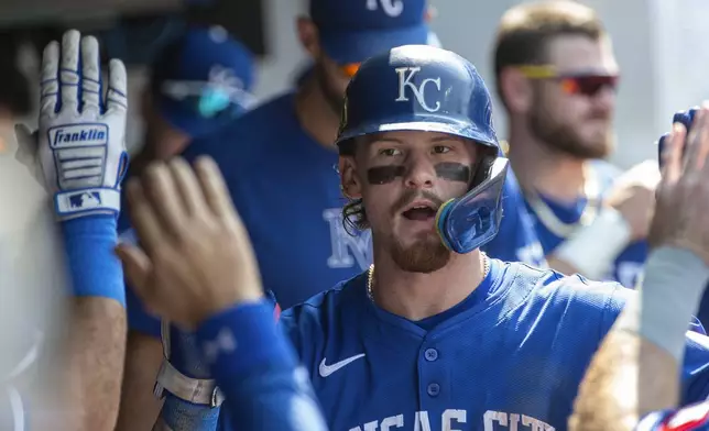 Kansas City Royals' Bobby Witt Jr. is congratulated by his teammates after hitting a solo home run off Cleveland Guardians relief pitcher Hunter Gaddis inning of the first game of a baseball doubleheader in Cleveland, Monday, Aug. 26, 2024. (AP Photo/Phil Long)