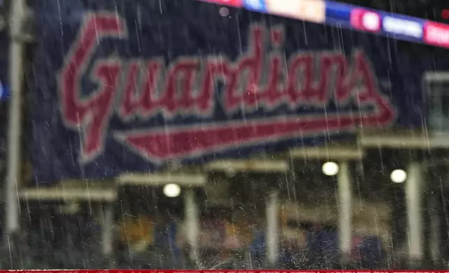 Rain bounces off a railing at Progressive Field during a rain delay in the fifth inning of a baseball game between the Kansas City Royals and the Cleveland Guardians, Tuesday, Aug. 27, 2024, in Cleveland. (AP Photo/Sue Ogrocki)