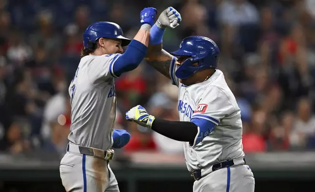 Kansas City Royals' Bobby Witt Jr. and Salvador Perez celebrate after a grand slam hit by Perez during the sixth inning of the second game of a baseball doubleheader against the Cleveland Guardians, Monday, Aug. 26, 2024, in Cleveland. (AP Photo/Nick Cammett)