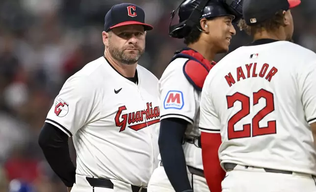 Cleveland Guardians manager Stephen Vogt, left, makes a pitching change during the sixth inning of the second game of a baseball doubleheader against the Kansas City Royals, Monday, Aug. 26, 2024, in Cleveland. (AP Photo/Nick Cammett)