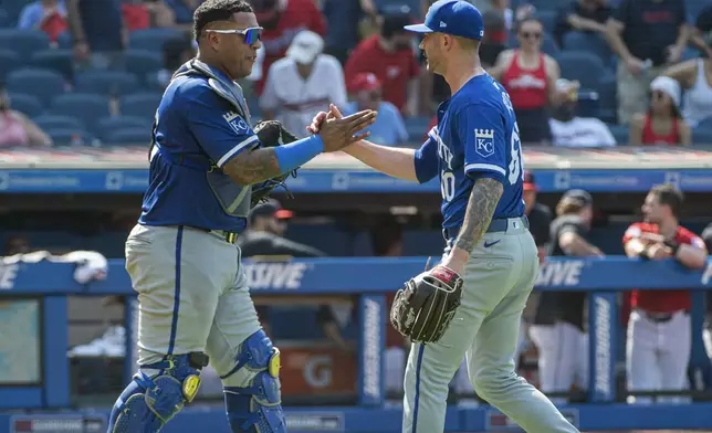 Kansas City Royals' Salvador Perez, left, congratulates Lucas Erceg, right, at the end of the first game of a baseball doubleheader against the Cleveland Guardians in Cleveland, Monday, Aug. 26, 2024. (AP Photo/Phil Long)