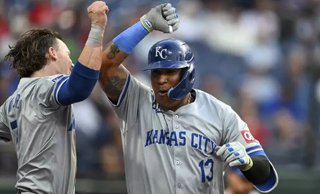 Kansas City Royals' Salvador Perez (13) and Bobby Witt Jr., left, celebrate after a solo home run by Perez during the fifth inning of the second game of a baseball doubleheader against the Cleveland Guardians, Monday, Aug. 26, 2024, in Cleveland. (AP Photo/Nick Cammett)