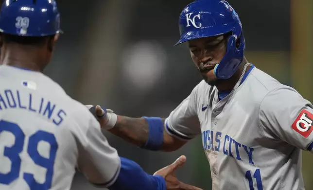 Kansas City Royals' Maikel Garcia, right, celebrates his single with first base coach Damon Hollins (39) in the seventh inning of a baseball game against the Cleveland Guardians, Tuesday, Aug. 27, 2024, in Cleveland. (AP Photo/Sue Ogrocki)