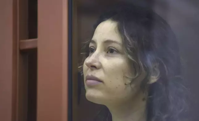 Ksenia Karelina, also known as Khavana sits in a glass cage in a court room in Yekaterinburg, Russia, Thursday, Aug. 15, 2024. A Russian court on Thursday sentenced U.S.-Russian dual national Ksenia Khavana to 12 years in prison on a treason conviction for allegedly raising money for the Ukrainian military. (AP Photo)