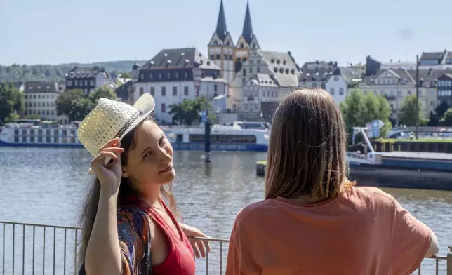 Freed Russian artist Sasha Skochilenko, left, and her partner, Sofya Subbotina, stand at the banks of the Mosel River in Koblenz, Germany, Saturday, Aug. 10, 2024. (AP Photo/Michael Probst)