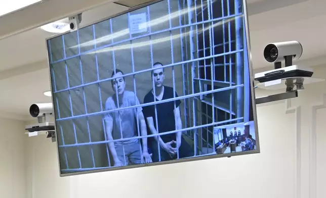 Alexei Liptser, left, and Vadim Kobzev, lawyers for Alexei Navalny, are seen on the screen in a video link provided by the Russian Federal Penitentiary Service during a session in Moscow City Court as the court considers an appeal on the pretrial detention, in Moscow, Russia, Tuesday, Aug. 20, 2024. (AP Photo/Dmitry Serebryakov)