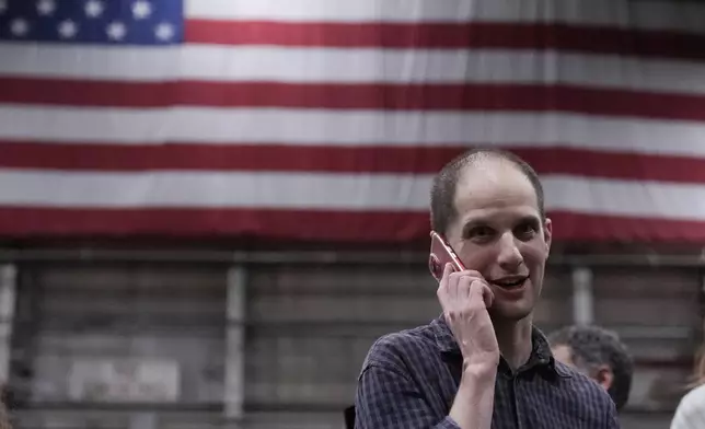 Evan Gershkovich talks on the phone after he arrived at Kelly Field after being released by Russia, Friday, Aug. 2, 2024, in San Antonio. (AP Photo/Eric Gay)