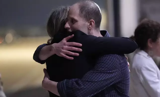 Evan Gershkovich, right, is hugged as he arrives at Kelly Field after being released by Russia, Friday, Aug. 2, 2024, in San Antonio. (AP Photo/Eric Gay)