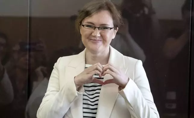 FILE - Lilia Chanysheva makes a heart gesture as she stands in a cage during a hearing in Kirovskiy District Court in Ufa, Russia, on Wednesday, June 14, 2023. Chanysheva, a former associate of the late opposition politician Alexei Navalny, was convicted in 2023 of extremism charges, widely seen as politically motivated, and sentenced to 9½ years in prison. (AP Photo, File)