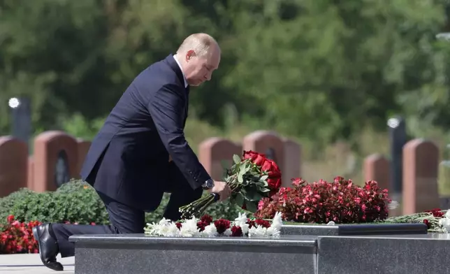 Russian President Vladimir Putin lays flowers at the City of Angels cemetery, where the victims of the 2004 Beslan school siege were buried, in Beslan, Republic of North Ossetia-Alania, Russia, Tuesday, Aug. 20, 2024. (Gavriil Grigorov, Sputnik, Kremlin Pool Photo via AP)