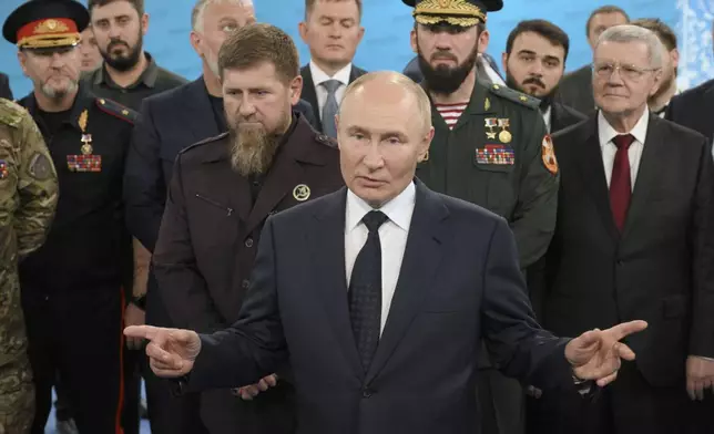 Russian President Vladimir Putin, accompanied by Head of the Chechen Republic Ramzan Kadyrov, centre left, Prime Minister of the Chechen Republic Magomed Daudov, and Presidential Envoy to the North Caucasian Federal District Yury Chaika, right, talks to servicemen during his visit to the Special Forces University in Gudermes, Chechen Republic, Russia, Tuesday, Aug. 20, 2024. (Alexei Danichev, Sputnik, Kremlin Pool Photo via AP)