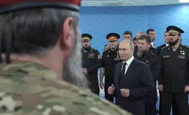 Russian President Vladimir Putin, accompanied by Head of the Chechen Republic Ramzan Kadyrov, second right, and Prime Minister of the Chechen Republic Magomed Daudov talks to servicemen during his visit to the Special Forces University in Gudermes, Chechen Republic, Russia, Tuesday, Aug. 20, 2024. (Alexei Danichev, Sputnik, Kremlin Pool Photo via AP)